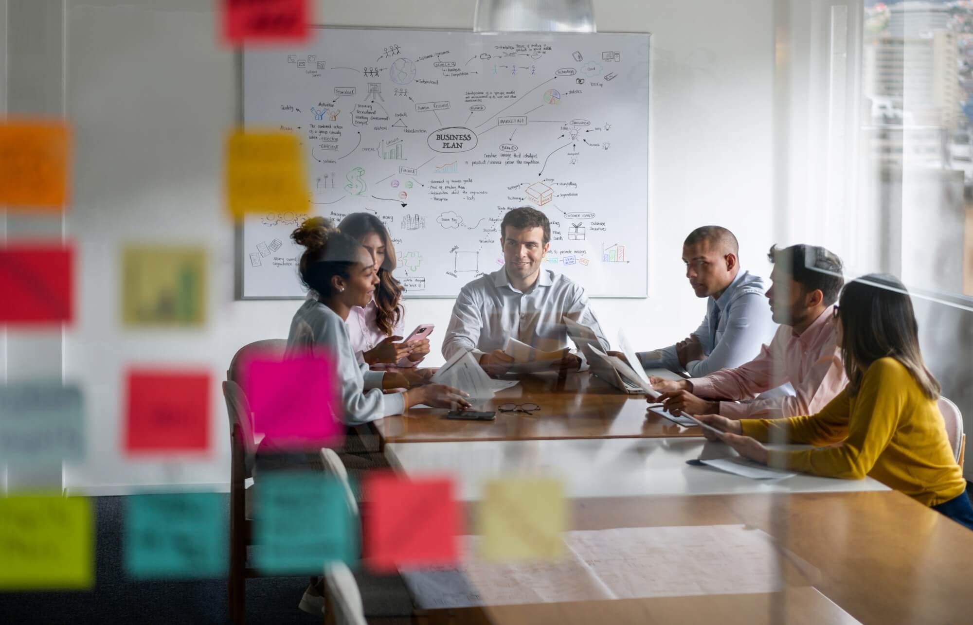 Business plan meeting with staff members in discussion around a desk