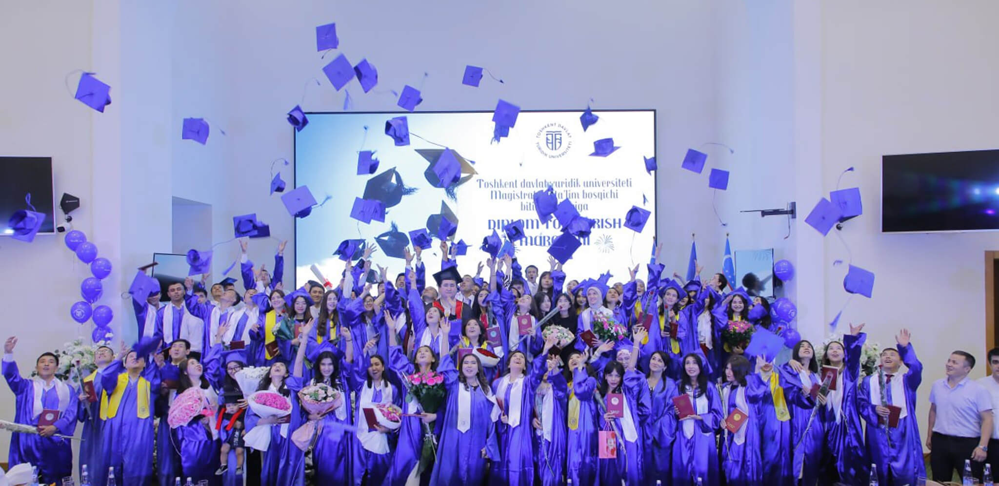 Tashkent State University of Law students throwing graduation caps