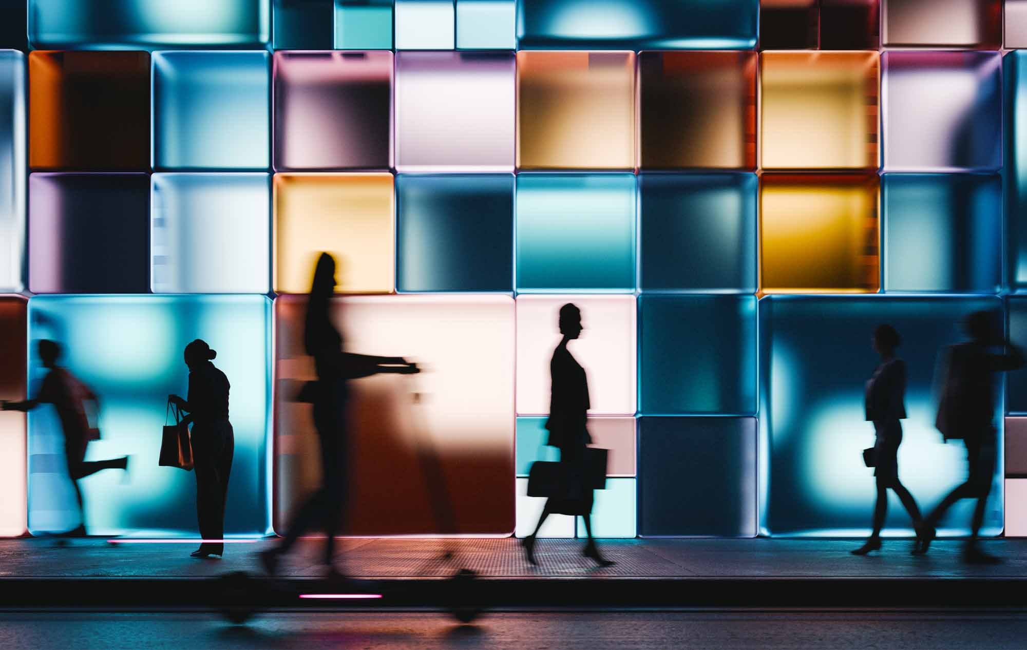 A building made of glowing cubes, people walking past