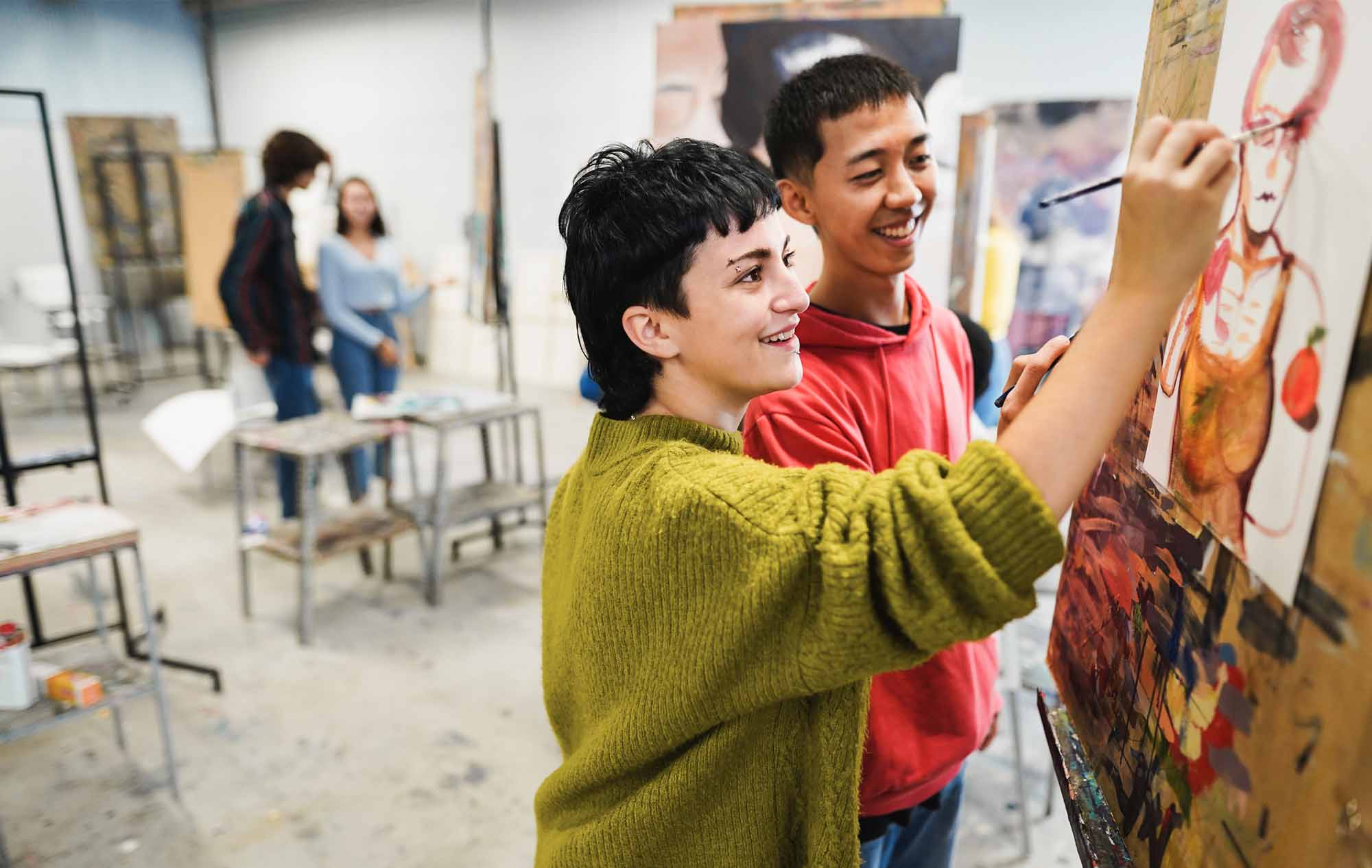 students painting inside art room class at school