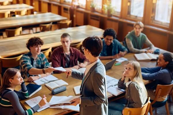 Image of students sitting around a big desk